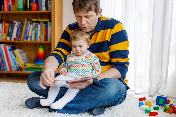 Young father reading book with his cute adorable baby daughter girl — Stock Photo, Image