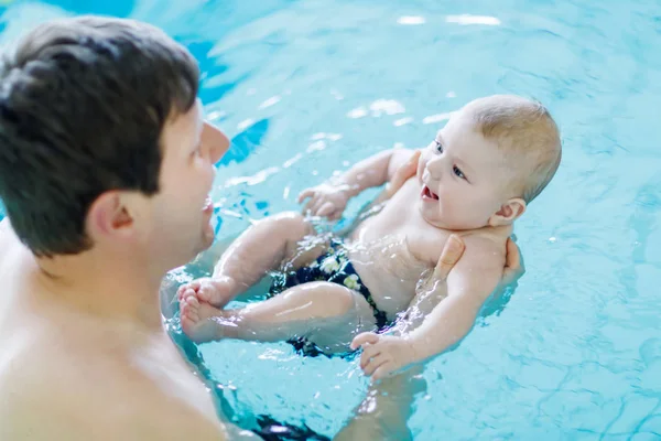 Szczęśliwy ojciec średnim wieku pływanie z cute adorable baby w basenie. — Zdjęcie stockowe