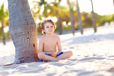 Sarışın küçük çocuk çocuk Miami beach, Key Biscayne üzerinde eğleniyor. Kumla oynayan ve okyanus yakın çalışan mutlu sağlıklı sevimli bir çocuk. Avuç içi, güvenlik ev ve beyaz kum. Güneşli sıcak parlak ışık ile