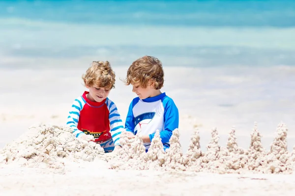Dwóch chłopców buduje zamek z piasku na tropikalnej plaży Playa del Carmen, Meksyk — Zdjęcie stockowe