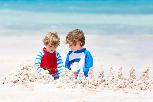 Playa del Carmen, Meksika 'da tropik plajlarda kumdan kale inşa eden iki çocuk. — Stok fotoğraf