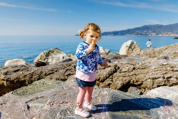 Nettes kleines Mädchen, das im Familienurlaub Eis in Tüten isst. glückliches gesundes Baby mit Eiswaffel. Italienische Riviera, Region Ligurien. cinque terre und portofinoin italien. — Stockfoto