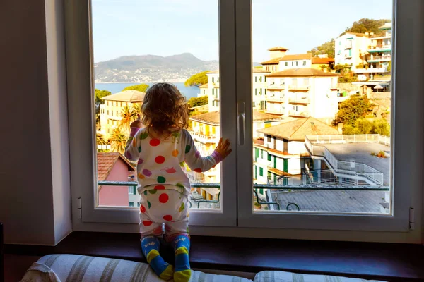 Bambina bambina che si gode la vista dalla finestra in mattinata sulla Liguria. Impressionanti borghi delle Cinque Terre e Portofino. Vacanze in famiglia nella città italiana con case colorate . — Foto Stock