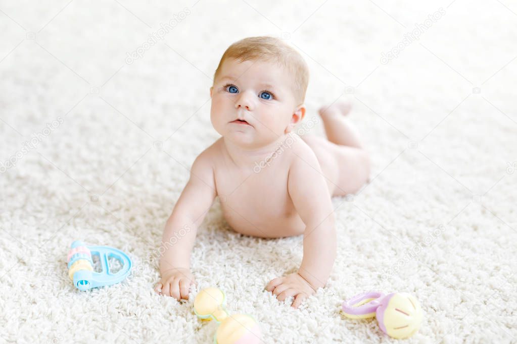 Cute baby girl playing with colorful pastel vintage rattle toy