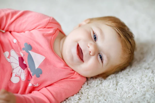 Liten söt baby flicka lära sig att krypa. Friskt barn kryper i barnrum med färgglada leksaker. Baksidan på baby ben. Söt liten knatte upptäcka hem och lära sig olika färdigheter — Stockfoto