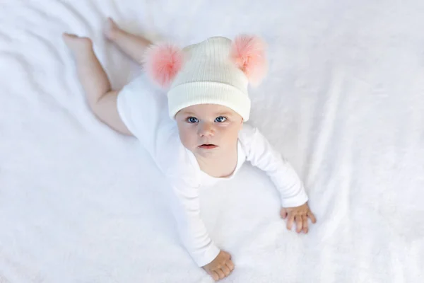 Bonito bebê adorável criança com chapéu branco e rosa quente com bobbles bonitos — Fotografia de Stock