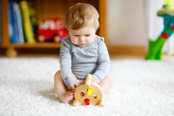 Adorable baby girl playing with educational toys . Happy healthy child having fun with colorful different wooden toy at home. Early development for children with nature toy. — Stock Photo, Image