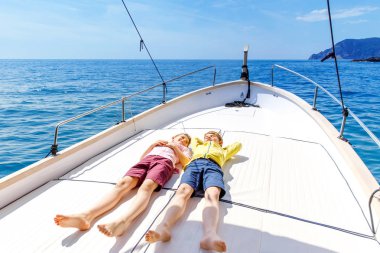 İki küçük çocuk, en iyi arkadaşlar yelkenli tekne gezisi zevk. Güneşli bir günde okyanus ta denizde aile tatilleri. Çocuklar gülümsüyor. Kardeşler, okul childen, kardeşler yatta eğleniyor.