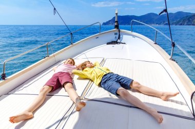 İki küçük çocuk, en iyi arkadaşlar yelkenli tekne gezisi zevk. Güneşli bir günde okyanus ta denizde aile tatilleri. Çocuklar gülümsüyor. Kardeşler, okul childen, kardeşler yatta eğleniyor.