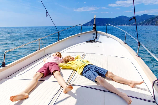 Due ragazzini, migliori amici che si godono una gita in barca a vela. Vacanze in famiglia sull'oceano o sul mare nelle giornate di sole. Bambini sorridenti. Fratelli, scolaretti, fratelli che si divertono sullo yacht . — Foto Stock