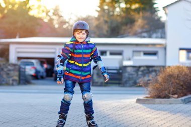 Sevimli okul çocuk çocuk şehrin silindirleriyle pateni. Mutlu sağlıklı çocuk koruma güvenlik elbiseleri Silindirler ile buz pateni. Spor yapma ve satır içi buz üzerinde paten öğrenme etkin öğrenci.