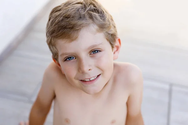 Gyönyörű mosolygós kisfiú portré a meleg napsütéses nyári napon. Happy kölyök a kamerába néz. Imádnivaló, szőke hajú és kék szemű gyermek. — Stock Fotó