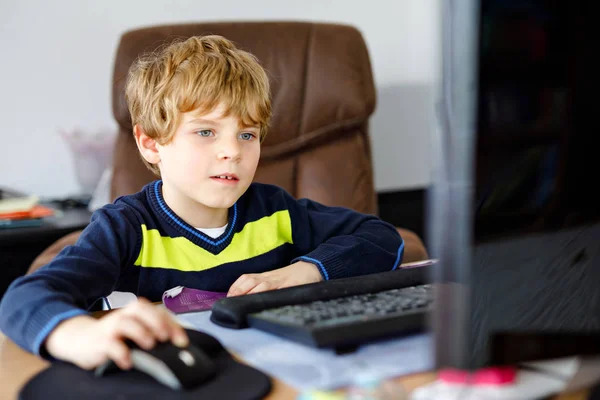 Un niño haciendo deberes escolares en un cuaderno de computadoras. Feliz niño sano buscando información en Internet. Nueva educación mediática, niño viendo lecciones de aprendizaje en la PC. Aula virtual . —  Fotos de Stock