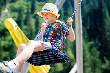 Komik çocuk çocuk iken ıslak olduğu su ile sıçrayan ile zincir salıncak açık sahada eğleniyor
