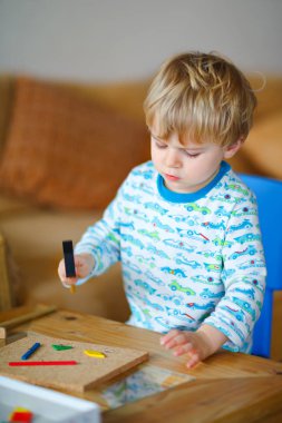 Atölyede ahşap çekiç aracıyla evde oynarken şirin yürümeye başlayan çocuk. Çocuk Çocuk tamirci oynamak. Çocuk Oluşturucusu'nu veya repairer oynarken, onarma veya handcrafting gece elbiseleri. Handcrafting kavramı.