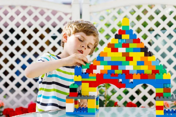 Küçük sarışın çocuk ve çocuk bir sürü renkli plastik blokla oynuyorlar.. — Stok fotoğraf