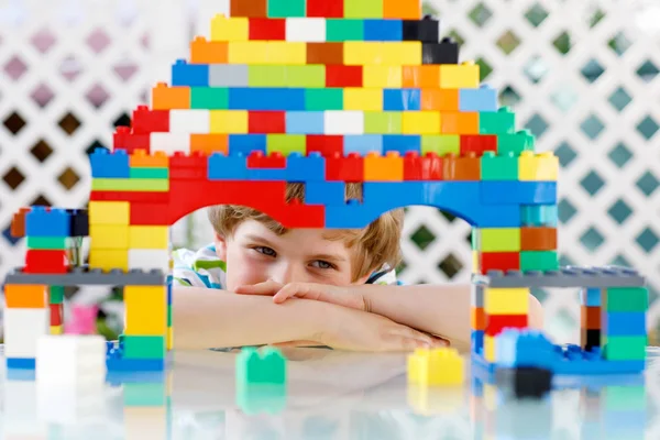 Niño rubio y niño jugando con un montón de bloques de plástico de colores. —  Fotos de Stock