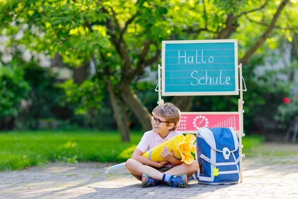 Niño feliz con gafas sentado junto al escritorio y la mochila o la mochila — Foto de Stock