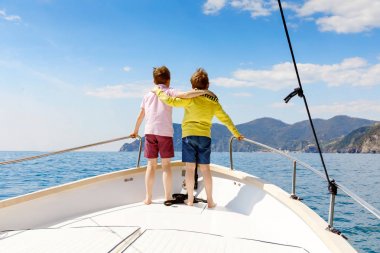 İki küçük çocuk, en iyi arkadaşlar yelkenli tekne gezisi zevk. Güneşli bir günde okyanus ta denizde aile tatilleri. Çocuklar gülümsüyor. Kardeşler, okul childen, kardeşler, yatta eğlenen en iyi arkadaşlar.