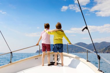 İki küçük çocuk, en iyi arkadaşlar yelkenli tekne gezisi zevk. Güneşli bir günde okyanus ta denizde aile tatilleri. Çocuklar gülümsüyor. Kardeşler, okul childen, kardeşler, yatta eğlenen en iyi arkadaşlar.