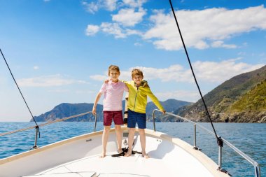 İki küçük çocuk, en iyi arkadaşlar yelkenli tekne gezisi zevk. Güneşli bir günde okyanus ta denizde aile tatilleri. Çocuklar gülümsüyor. Kardeşler, okul childen, kardeşler, yatta eğlenen en iyi arkadaşlar.