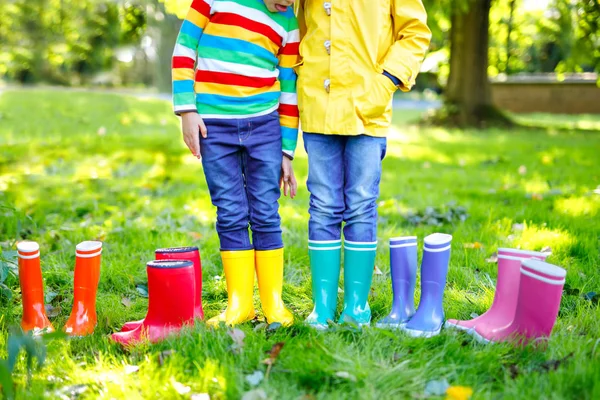 Małe dzieci, chłopców i dziewcząt w kolorowe kalosze. Zbliżenie: dzieci w różne gumowe buty, dżinsy i kurtki. Obuwie na deszczowa jesień — Zdjęcie stockowe