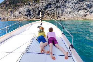 İki sevimli okul çocuk erkek, en iyi arkadaşlar yelkenli tekne gezisi zevk. Güneşli bir günde denizde aile tatilleri. Çocuklar gülümsüyor. Kardeşler, okul childen, kardeşler, yatta eğlenen en iyi arkadaşlar.