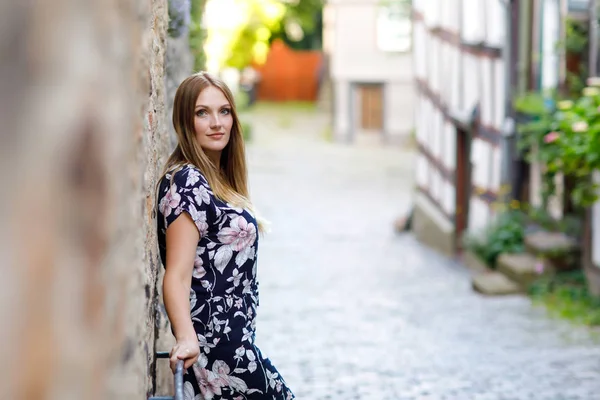 在德国城市散步的年轻漂亮的女人,穿着夏装,留着长发.在德国，快乐的女孩喜欢在有老房子的可爱小镇上散步. — 图库照片