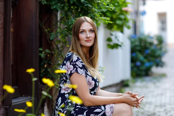 Schöne junge Frau mit langen Haaren im Sommerkleid, die in deutschen Städten spazieren geht. Glückliches Mädchen genießt Spaziergänge in netter Kleinstadt mit alten Häusern in Deutschland. — Stockfoto