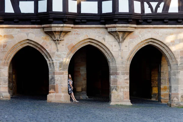 Mulher bonita com cabelos longos em vestido de verão indo para um passeio na cidade alemã. Menina feliz gostando de andar em bonito pequena cidade fachwerk com casas antigas na Alemanha. — Fotografia de Stock