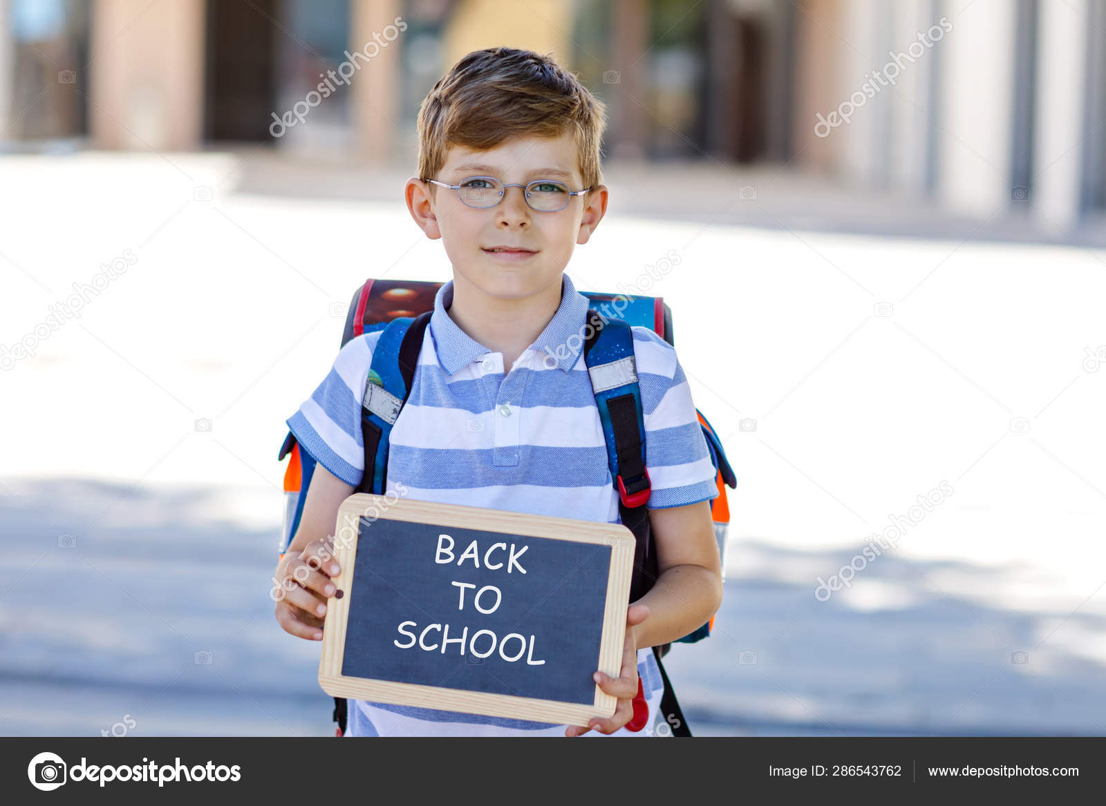 Heureux petit garçon en chemise colorée et sac à dos ou sacoche lors de son  premier