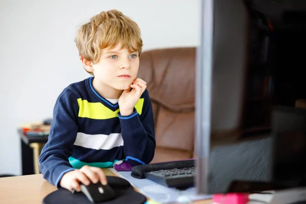 Un niño haciendo deberes escolares en un cuaderno de computadoras. Feliz niño sano buscando información en Internet. Nueva educación mediática, niño viendo lecciones de aprendizaje en la PC. Aula virtual . —  Fotos de Stock