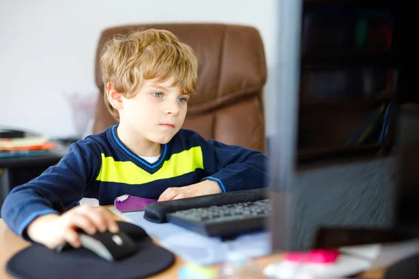 Un niño haciendo deberes escolares en un cuaderno de computadoras. Feliz niño sano buscando información en Internet. Nueva educación mediática, niño viendo lecciones de aprendizaje en la PC. Aula virtual . —  Fotos de Stock