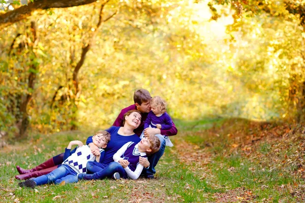 Portret van jonge ouders met drie kinderen. Moeder, vader, twee kinderen broers jongens en kleine schattige peuter zus meisje hebben plezier samen in de herfst bos. Gelukkige familie van vijf — Stockfoto
