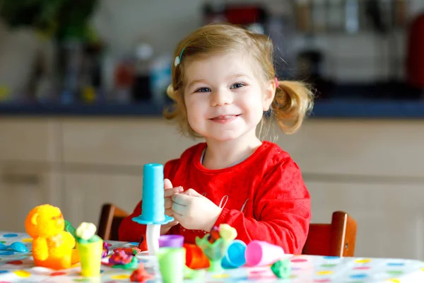 Förtjusande söt liten småbarn flicka med färgglada lera. Friska barn leker och skapar leksaker från lekdeg. Små barn formning modellera lera och lärande — Stockfoto