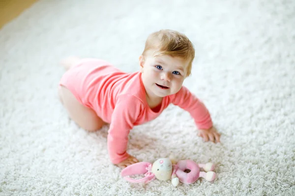 Niña linda aprendiendo a gatear. Niño sano arrastrándose en la habitación de los niños con juguetes de colores. Vista trasera de las piernas del bebé. Lindo niño descubriendo el hogar y aprendiendo diferentes habilidades —  Fotos de Stock