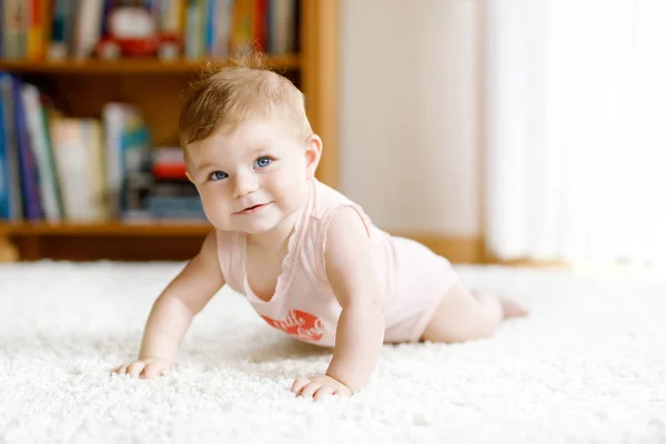 Pouco engraçado bebê menina levantando corpo e aprender a rastejar. — Fotografia de Stock