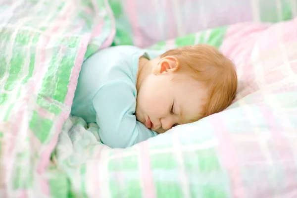 Очаровательная маленькая девочка спит в постели. Спокойный мирный ребенок мечтает во время дневного сна. Прекрасный ребенок в кровати родителей. Концепция совместной жизни. — стоковое фото