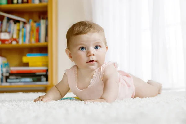 Pequeña niña divertida levantando cuerpo y aprendiendo a gatear. —  Fotos de Stock