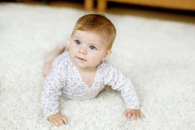 Küçük komik kız cesedi kaldırıyor ve emeklemeyi öğreniyor..