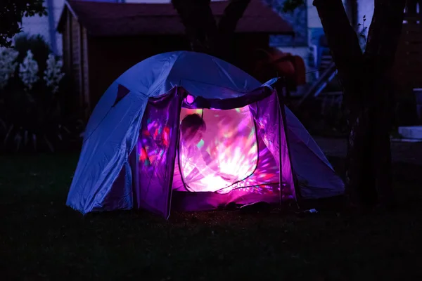 Tent with children inside glow in the night. Kids making overnight sleeping party in domestic garden. Adventure in summer vacations — Stock Photo, Image