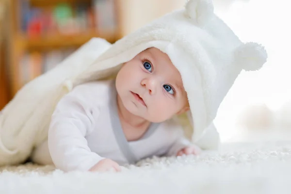 Baby girl wearing white towel or winter overal in white sunny bedroom — Stock Photo, Image