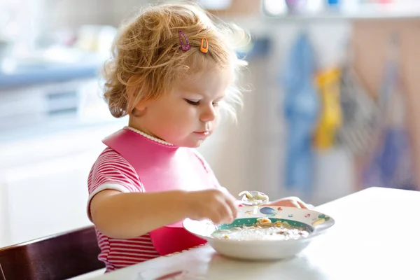 Αξιολάτρευτο κοριτσάκι που τρώει από σούπα λαχανικών. τροφή, παιδί, διατροφή και ανάπτυξη. Χαριτωμένο μικρό παιδί, κόρη με κουτάλι κάθεται σε καρεκλάκι και να μάθουν να τρώνε από μόνα τους — Φωτογραφία Αρχείου