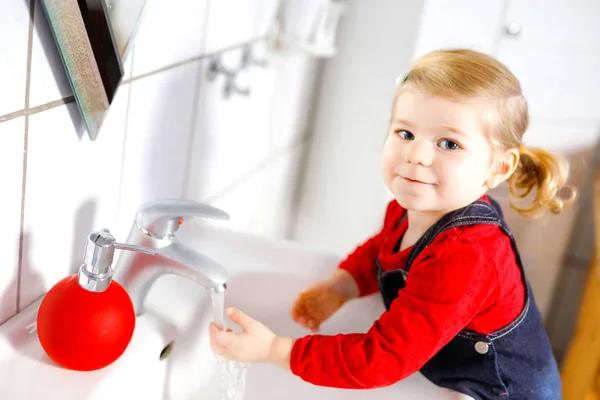 Słodka dziewczynka myje ręce mydłem i wodą w łazience. Urocze dziecko uczy się czyścić części ciała. Poranna higiena. Szczęśliwy zdrowy dzieciak w domu lub przedszkolu. — Zdjęcie stockowe