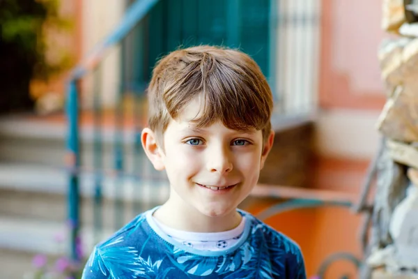 Portret van mooie prachtige school Kid jongen zittend Infront van huis. Gelukkige gezonde jongen op trappen door huis. — Stockfoto