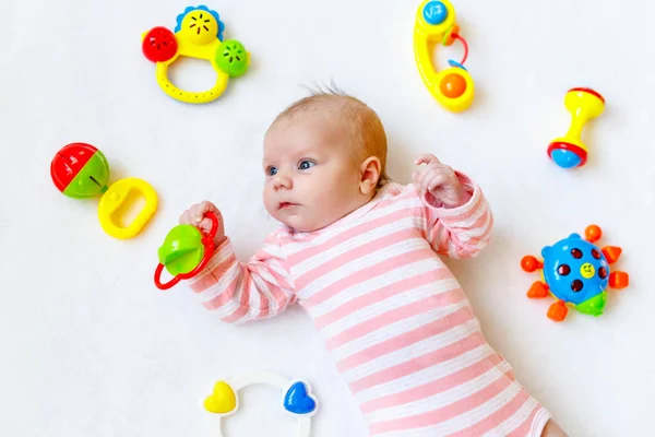 Cute baby girl playing with colorful rattle toys — Stock Photo, Image