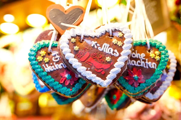 Peperkoek harten op de Duitse kerstmarkt. Neurenberg, München, Fulda, Berlijn, Hamburg Xmas markt in Duitsland. In de Duitse taal Merry Christmas. — Stockfoto