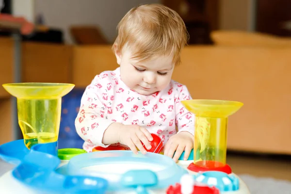 Adorable cute beautiful little baby girl playing with educational toys at home or nursery. Happy healthy child having fun and sorting colorful different plastic balls. Kid learning different skills — Stock Photo, Image
