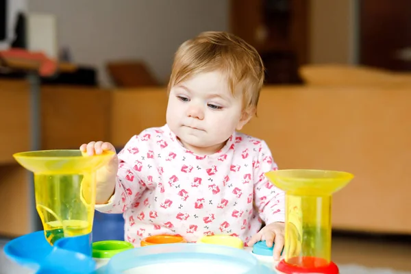 Adorable cute beautiful little baby girl playing with educational toys at home or nursery. Happy healthy child having fun and sorting colorful different plastic balls. Kid learning different skills — Stock Photo, Image