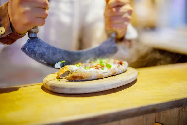 Traditional bread with sour cream and ham on German Christmas market. Closeup of fresh baked pretzel and hands of man on Xmas fair in Germany — Stock Photo, Image